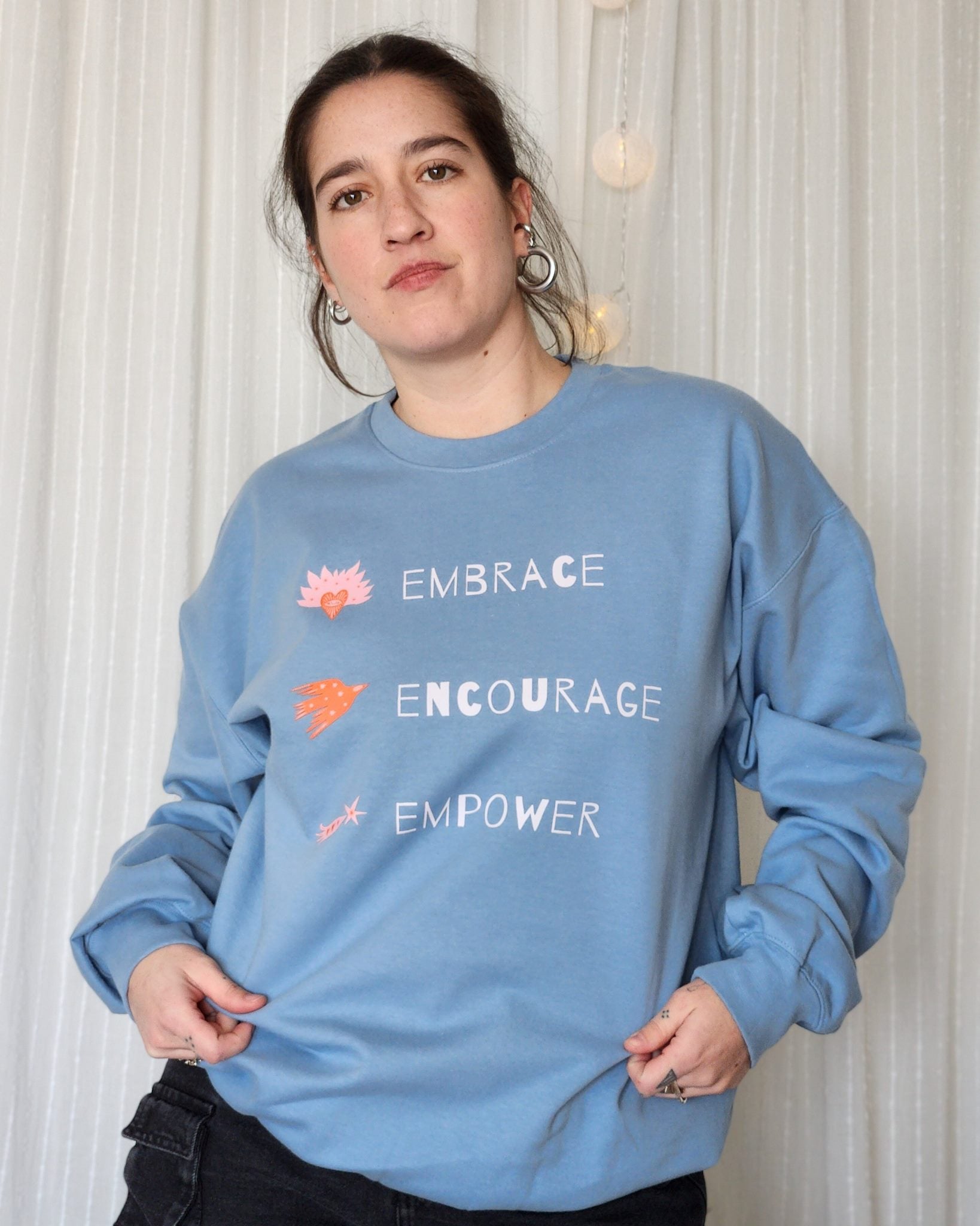 Person in a sweatshirt with a message that advocates for acceptance, diversity, and inclusion.